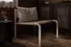 Kaski lounge chair by Joanna Laajisto showing ash wood frame with linen seat and leather cushion