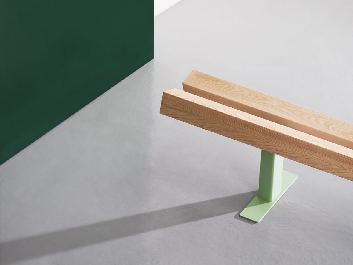 Ypsilon bench by Daniel Rybakken for Vestre featuring angled glulam beams on laser-cut galvanized steel base