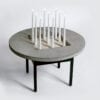 Jonas Bohlin Concrete Jungle table with round concrete top and black iron base in modern interior setting