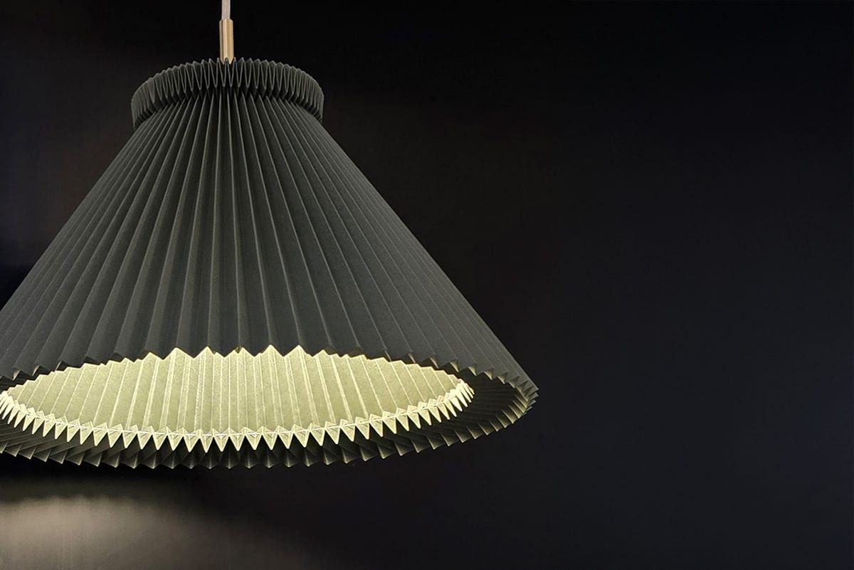 Den nya Moss Green-färgen på Le Klints ikoniska 1-serie lampskärmar, visar hantverk i pappersvikning