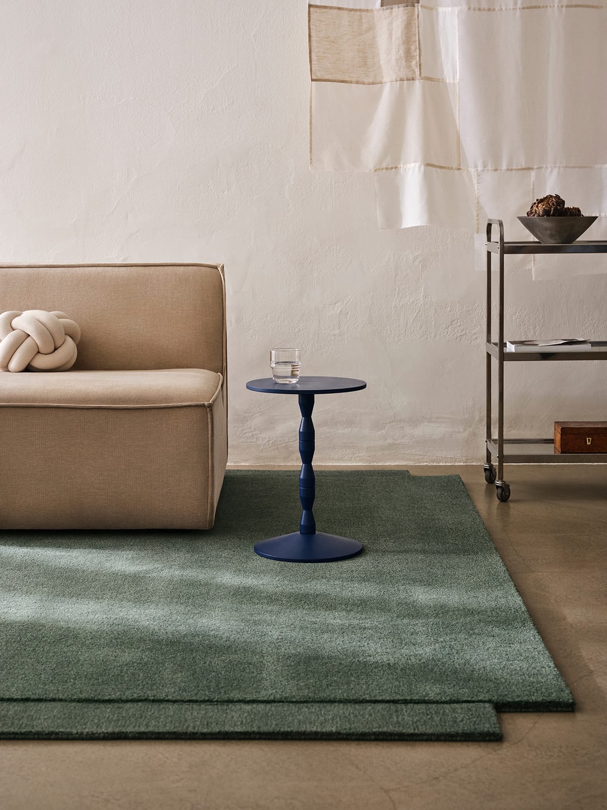Level Rug in green colorway anchoring a minimalist living space with furniture arranged to highlight its dimensional qualities.