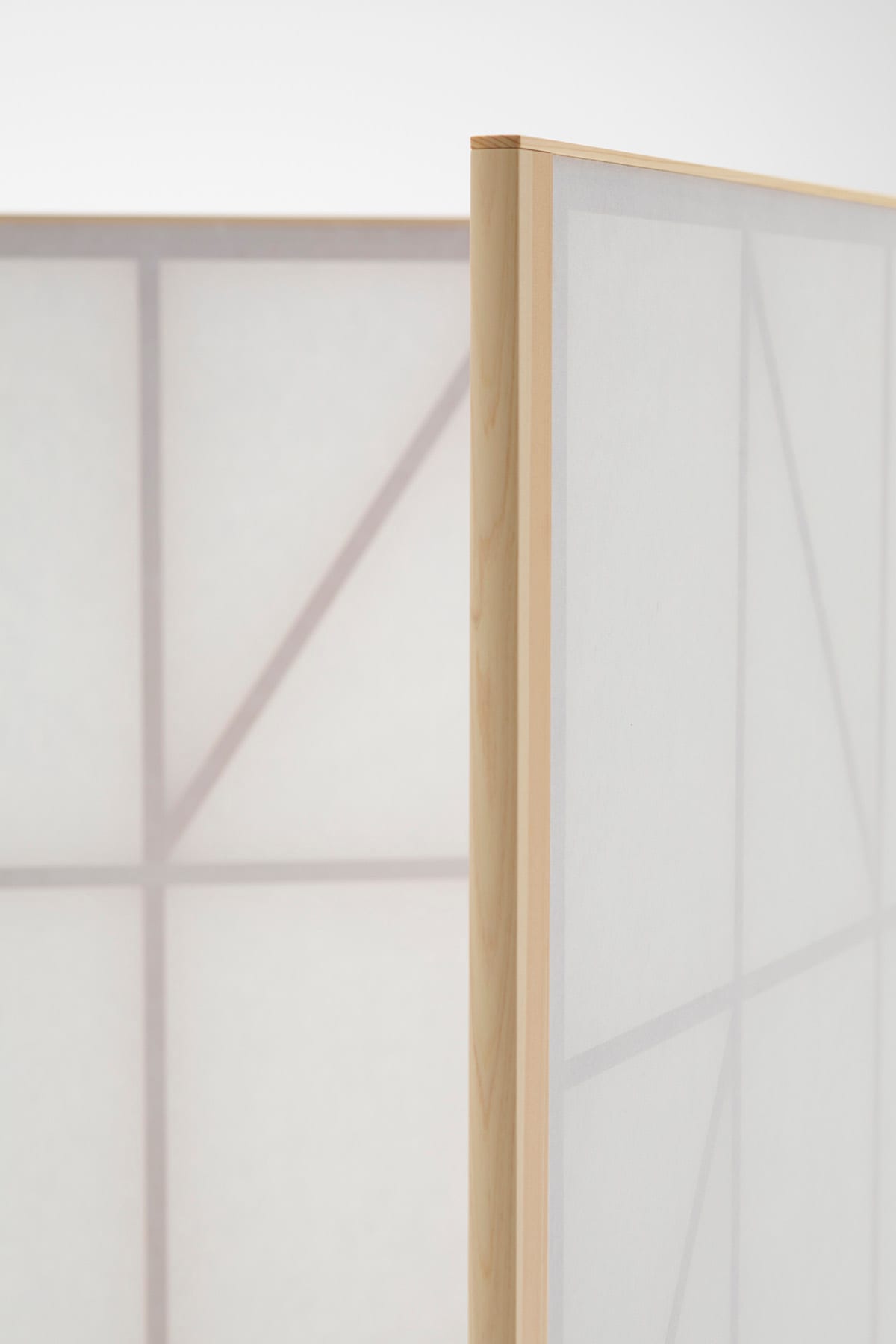 Washi paper version of Maku screen filtering natural light in a workspace, creating gentle shadows and visual privacy.