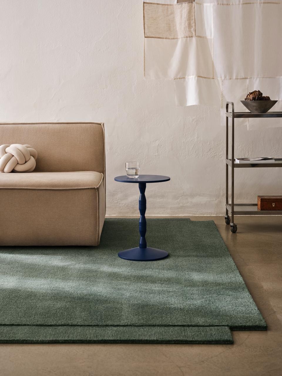 Matti Klenell's red Pedestal Table by Design House Stockholm in a living room setting displaying decorative objects