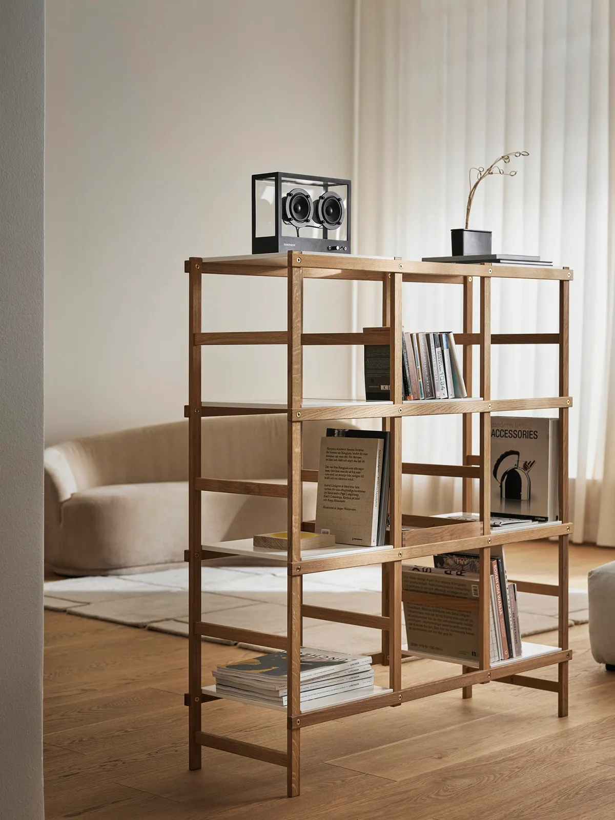 Frame shelving system by Harald Hermanrud showing open wood construction with brass hardware details