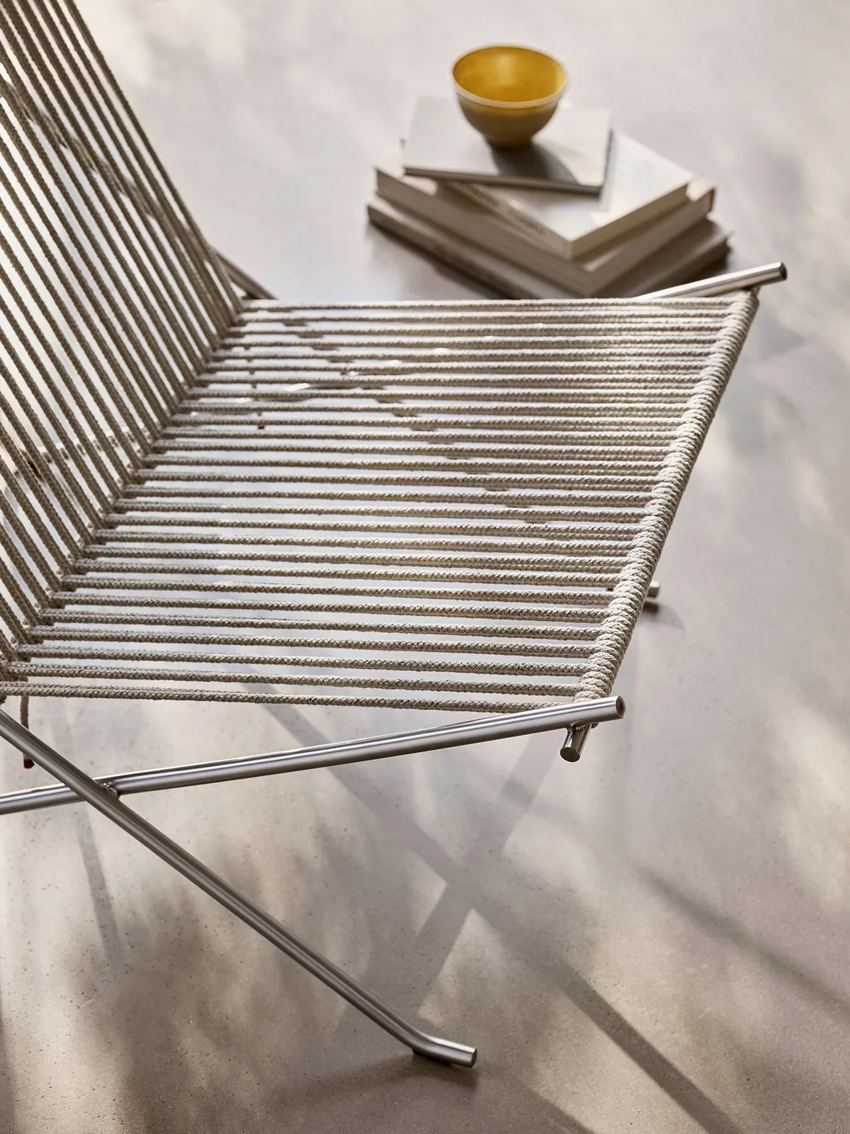 Close-up PK4 chair steel tubing and flag halyard weaving showing precision craftsmanship and material intersection