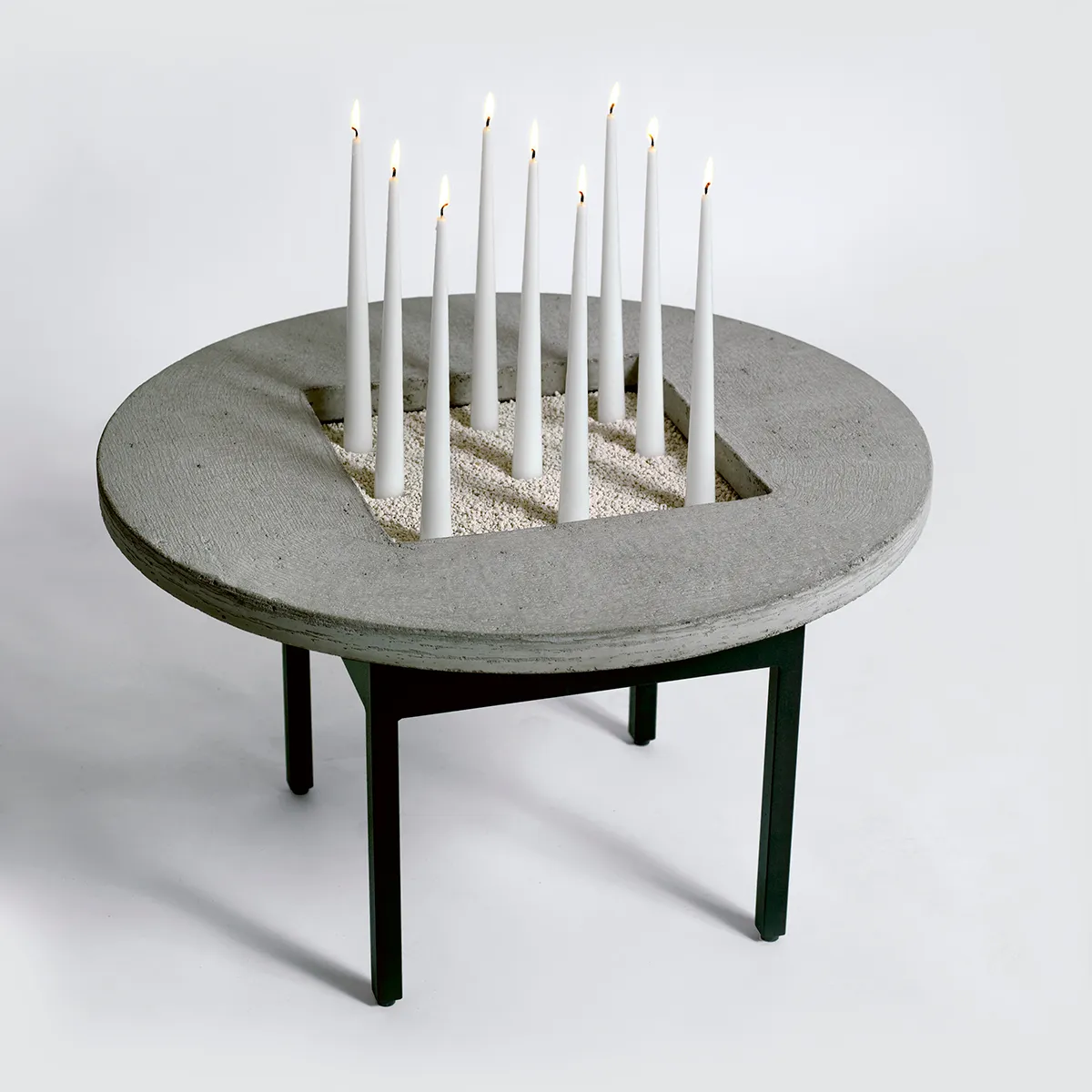 Jonas Bohlin Concrete Jungle table with round concrete top and black iron base in modern interior setting