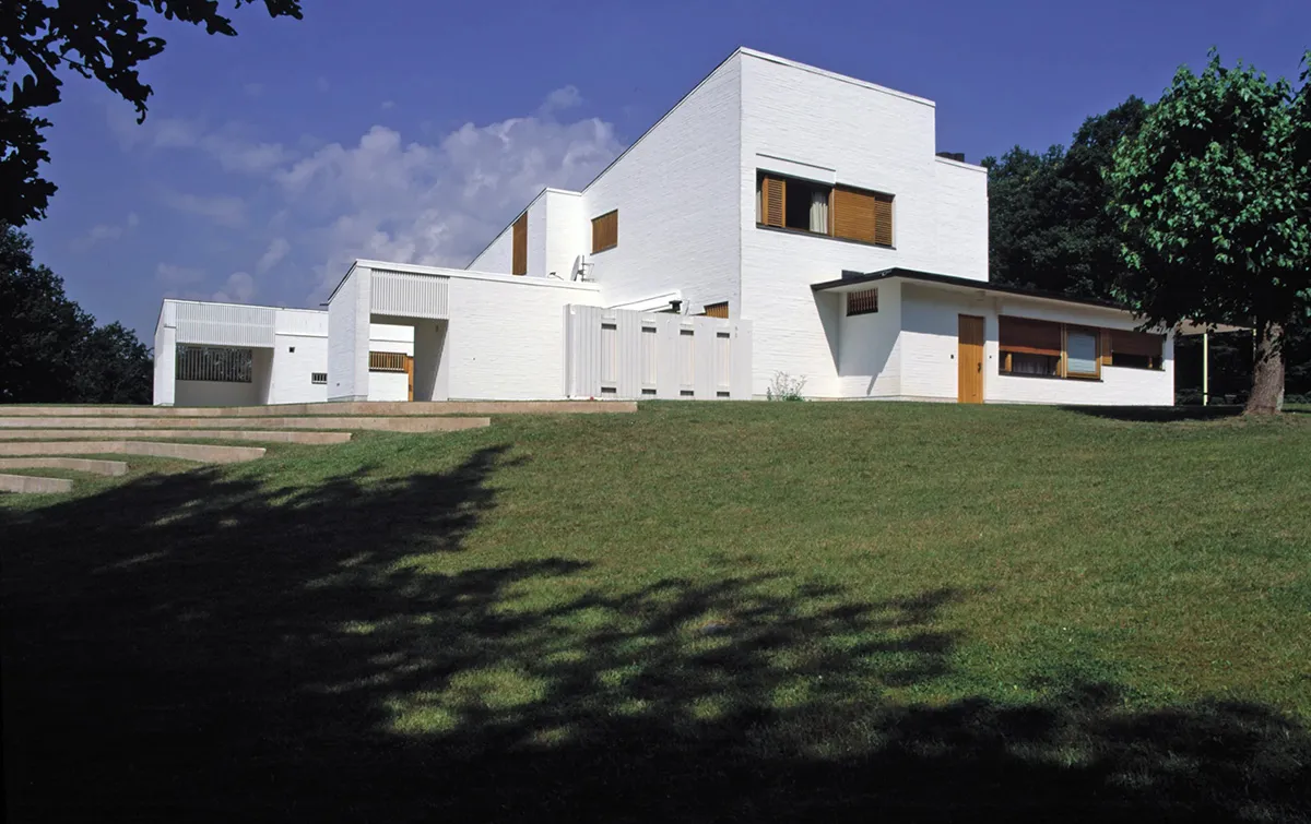 Exterior view of Maison Louis Carré showing Alvar Aalto's distinctive architecture with sloping roof and natural materials