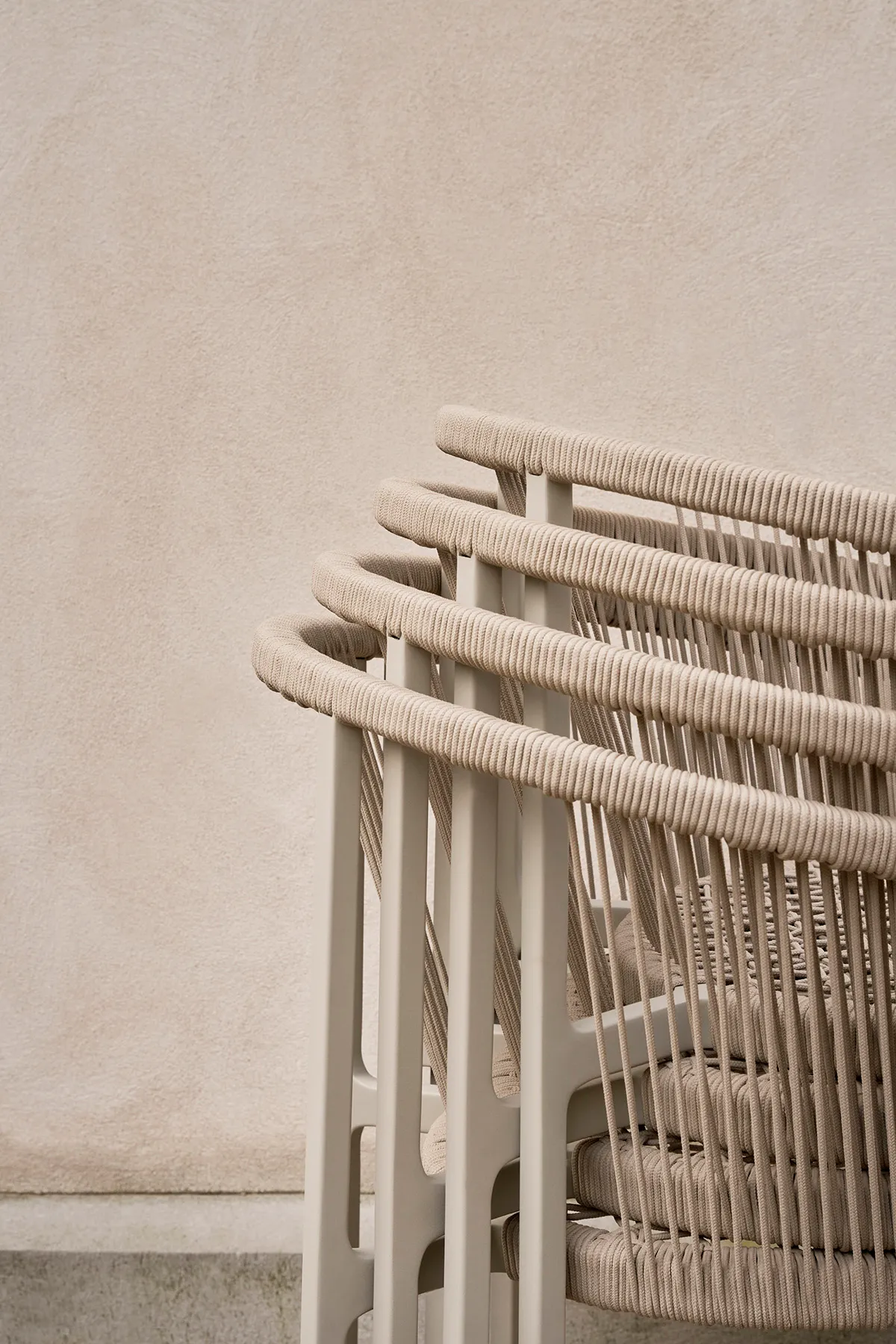 Close-up of Vipp Lagrasse chair showcasing the woven cord detail wrapping around the curved back and armrest frame
