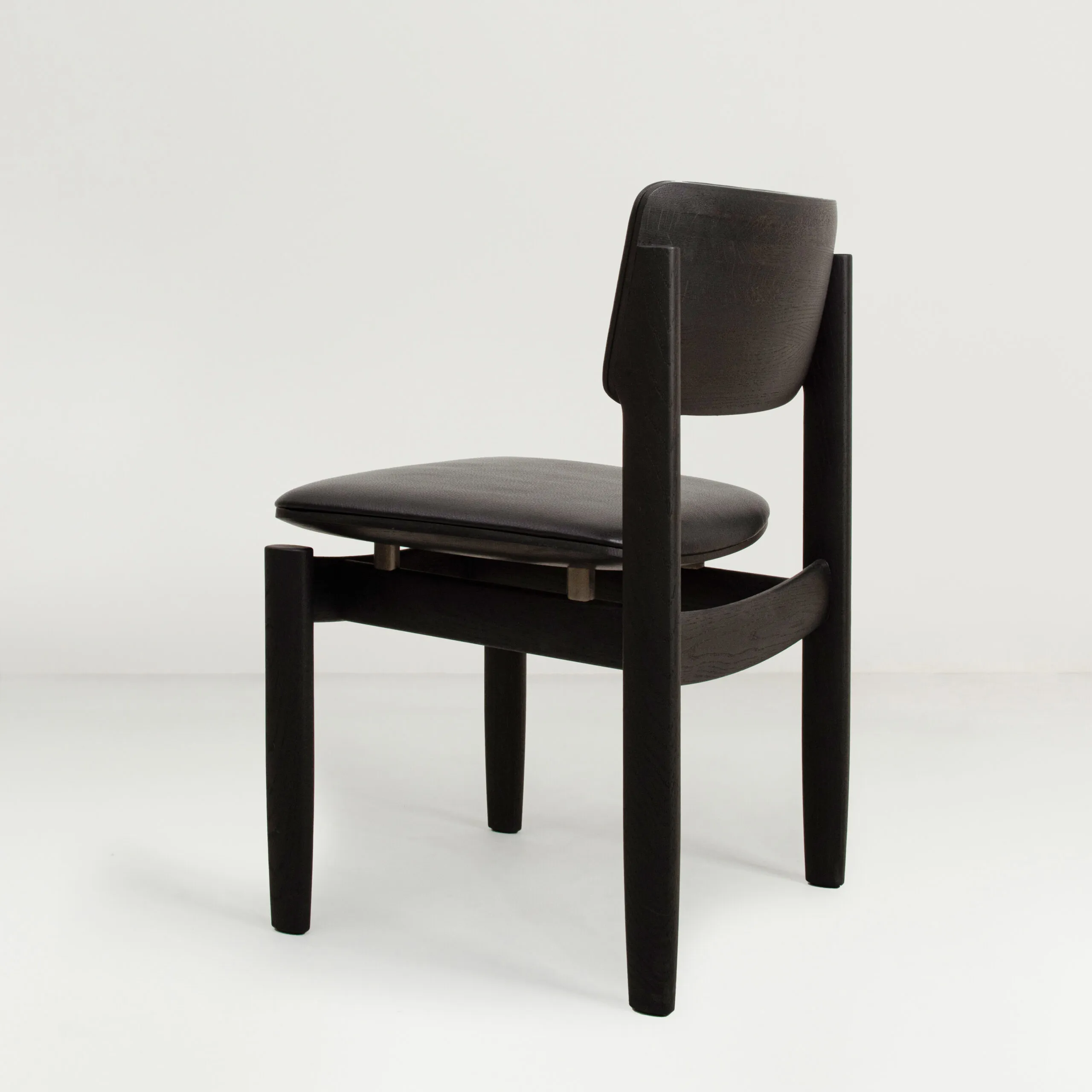 Side view of District Eight's Bow Chair highlighting the gravity-defying construction and ergonomic contours.