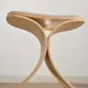 LUNO Stool in classic oak with beige textile seat displaying its distinctive curved lunar-inspired silhouette