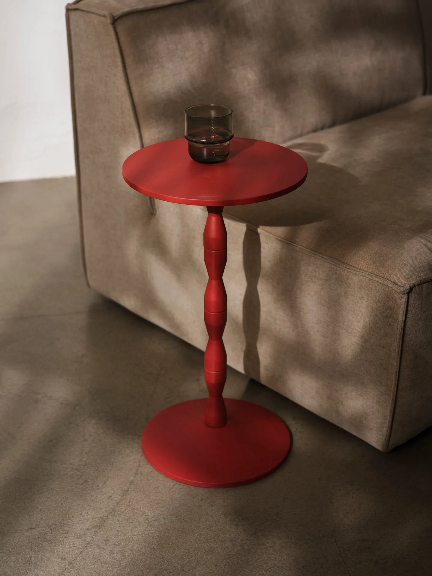 Red pedestal Table by Matti Klenell for Design House Stockholm displayed in office environment showing versatility as laptop stand and workspace
