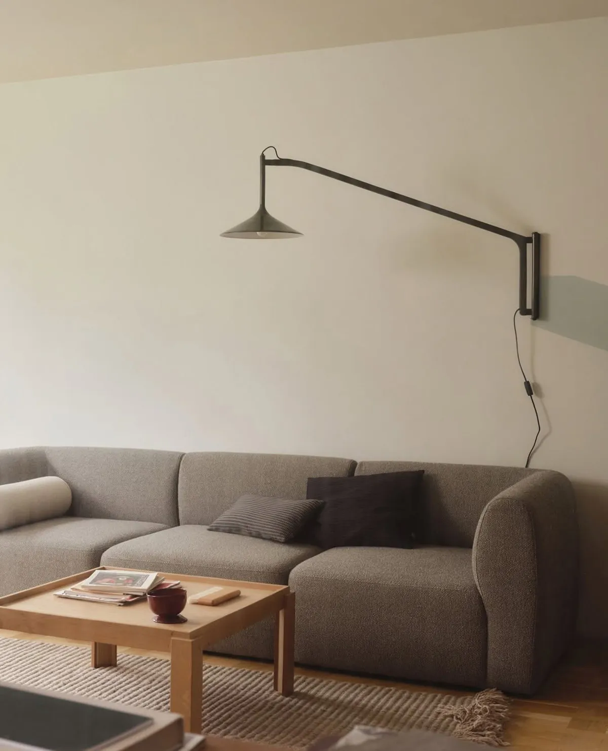 Laura Lange Hasle wall lamp for FDB Møbler in olive green with adjustable trumpet-form shade against neutral wall