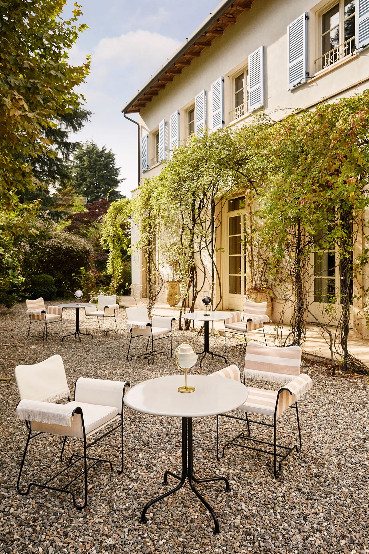 Elegant Clam White Carmel Bistro Table by OEO Studio for Gubi, featuring a weather-resistant ceramic top with rounded pebble-like silhouette and tree-like leg assembly.