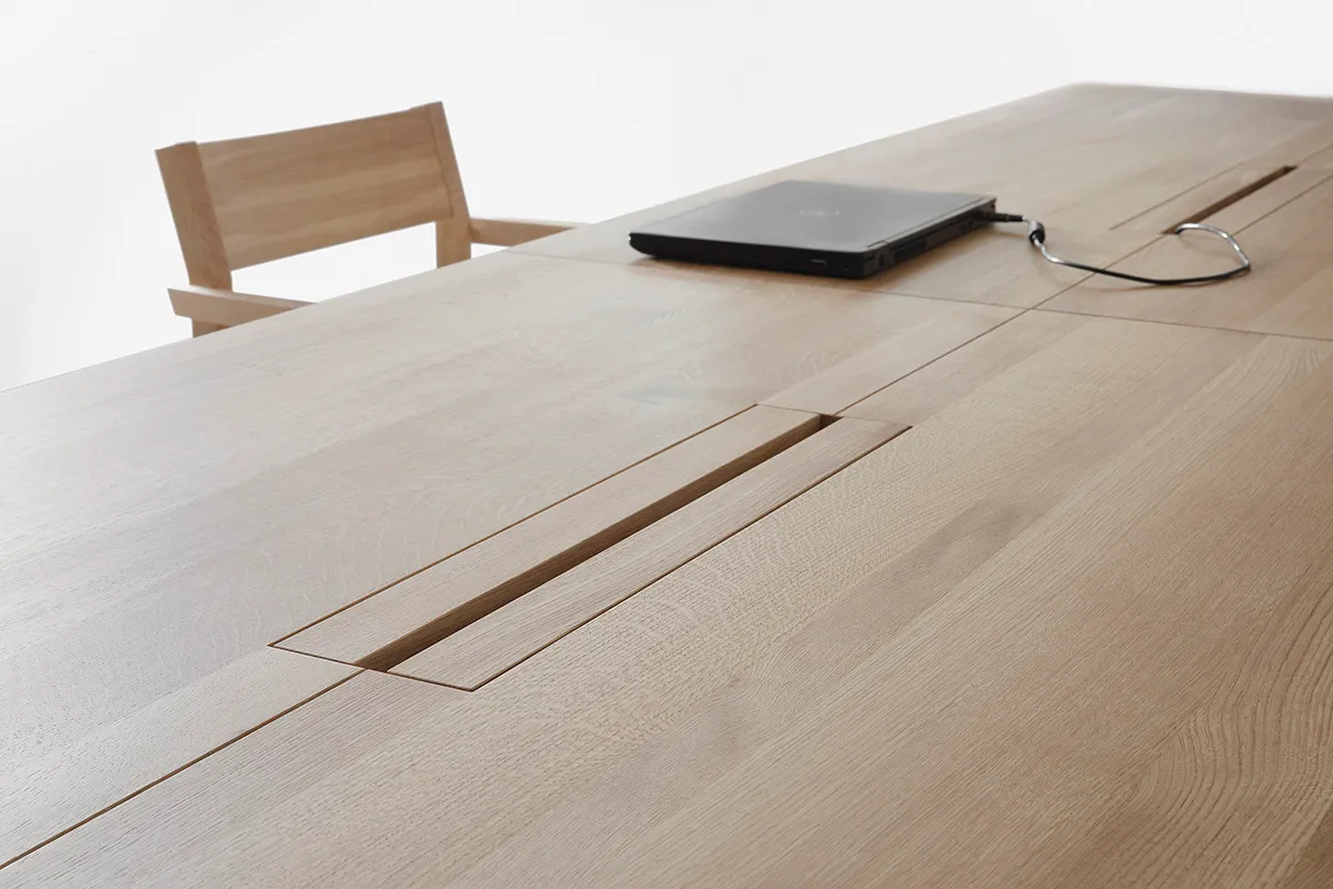 Close-up of LINEA KVP11 table's storage solution for digital technology, evidence of Nikari's innovative design