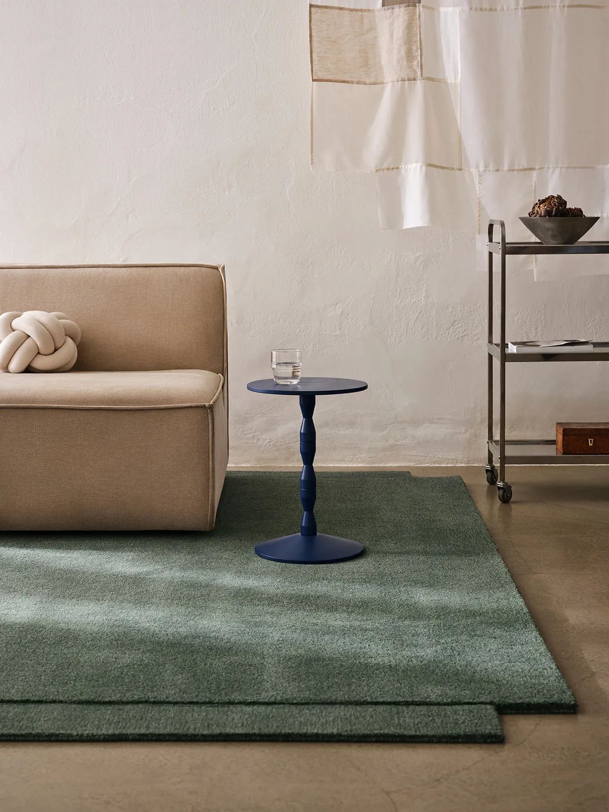 Level Rug in green colorway anchoring a minimalist living space with furniture arranged to highlight its dimensional qualities.