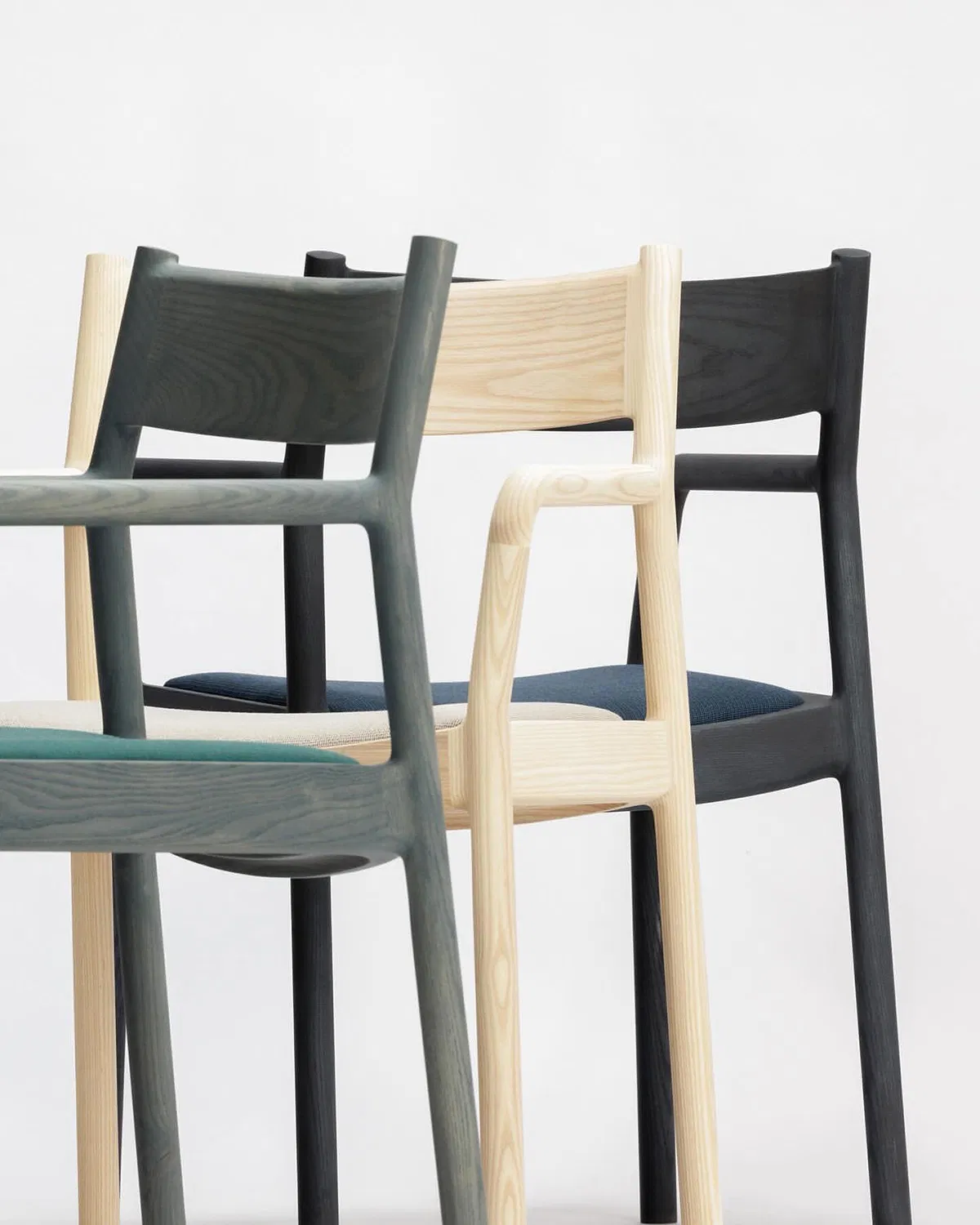 Side profile of the GLC 01 lounge chair showing its distinctive silhouette and balanced proportions in solid ash wood.