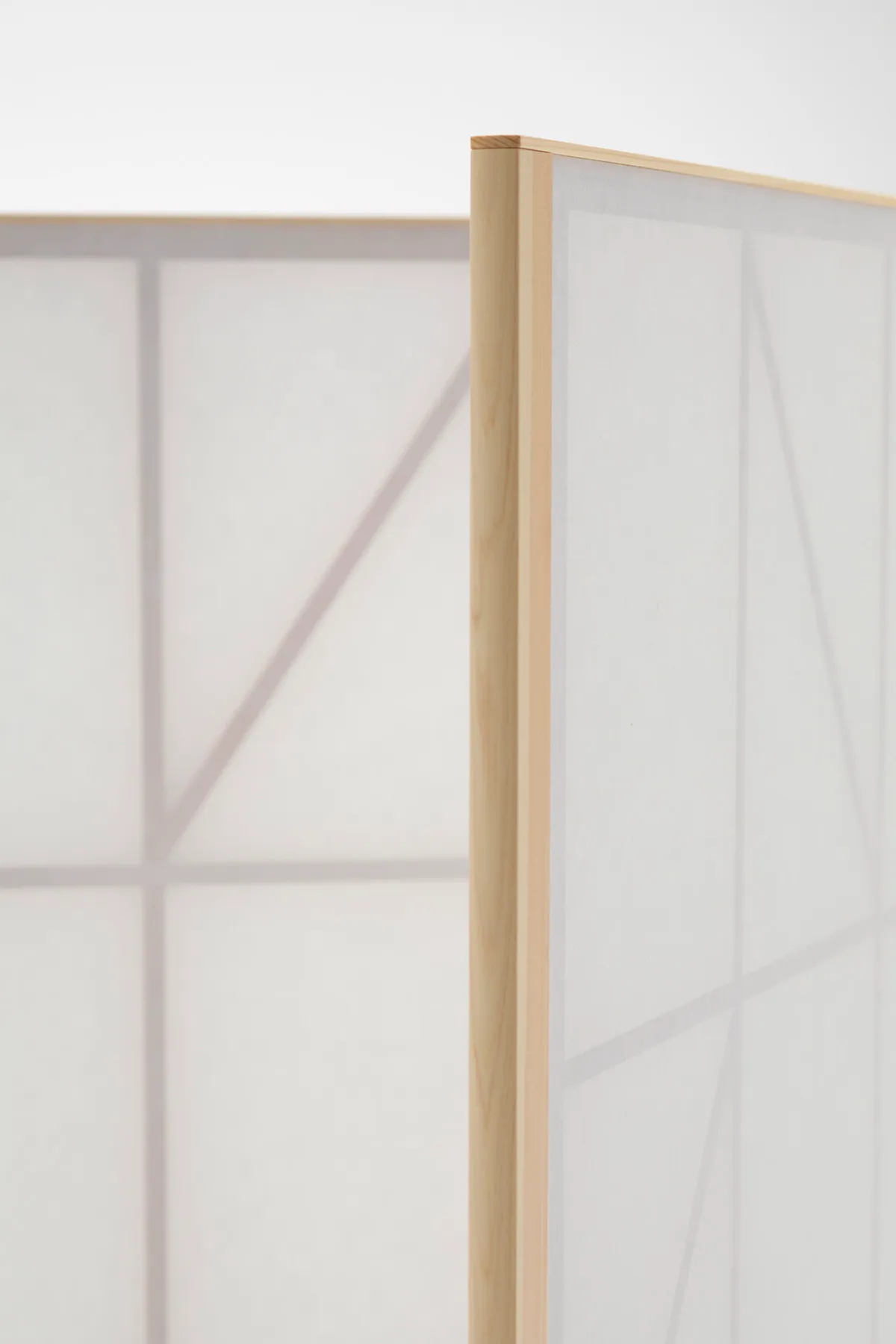 Washi paper version of Maku screen filtering natural light in a workspace, creating gentle shadows and visual privacy.