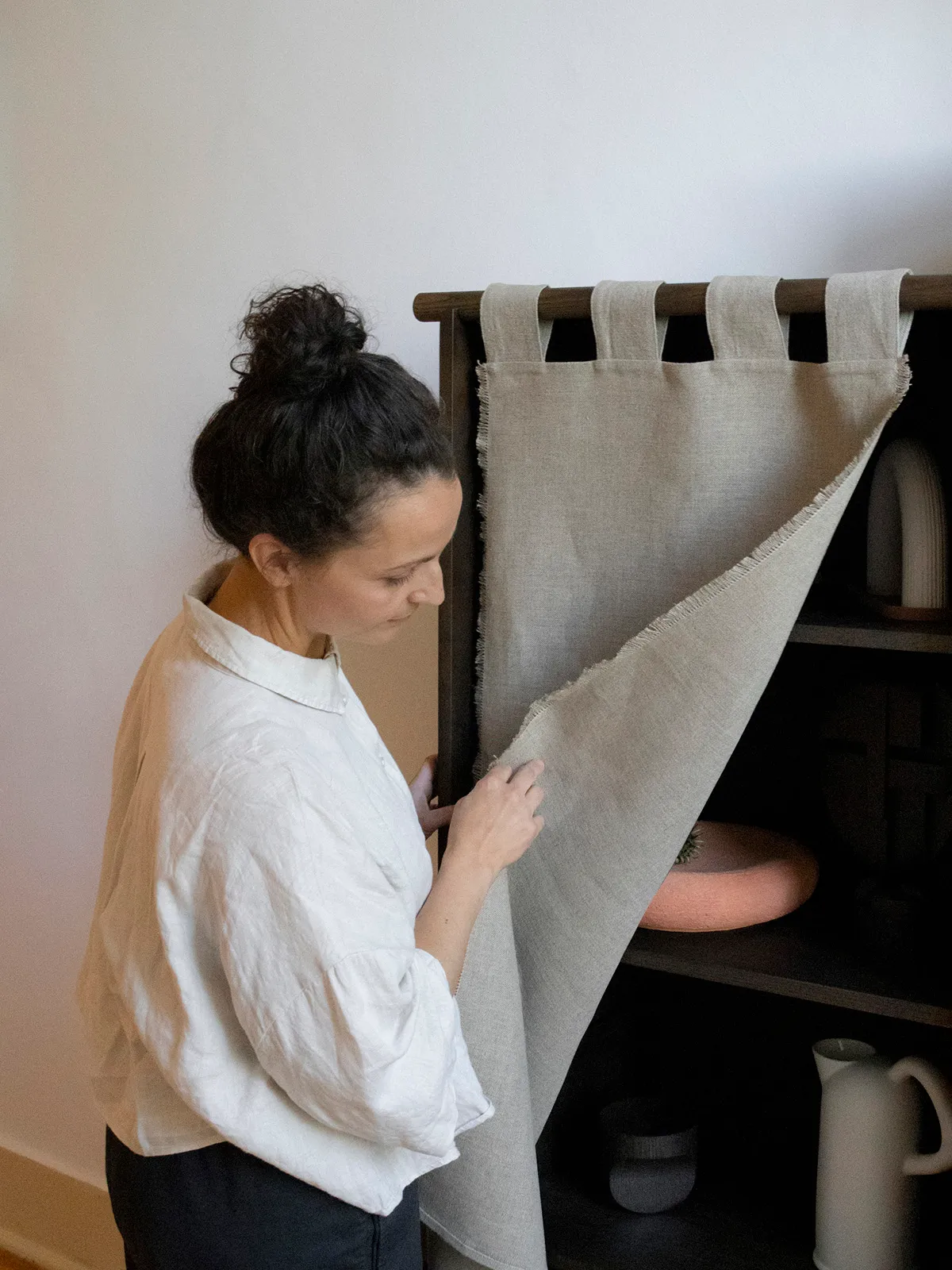 Designer Silje Nesdal examining the linen detail of her Veil Cabinet creation for Origin Made.