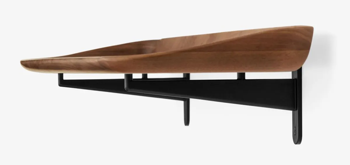 Close-up detail of Guild shelf's distinctive curved edge and brass mounting hardware showing expert craftsmanship