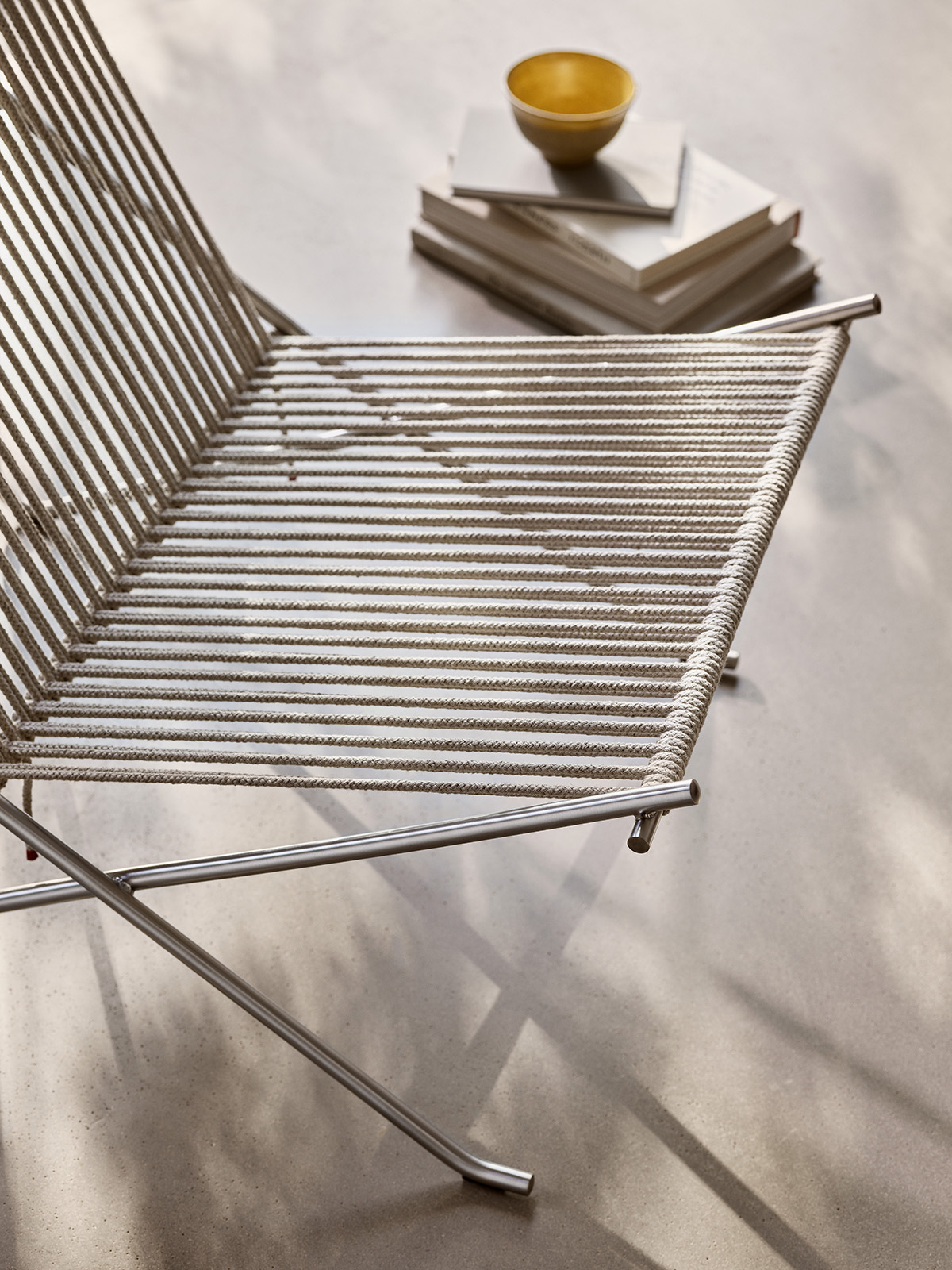 Close-up PK4 chair steel tubing and flag halyard weaving showing precision craftsmanship and material intersection
