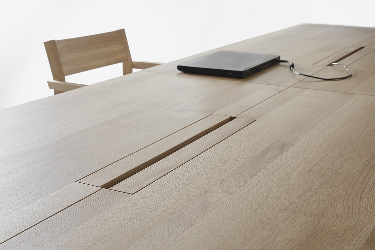 Close-up of LINEA KVP11 table's storage solution for digital technology, evidence of Nikari's innovative design