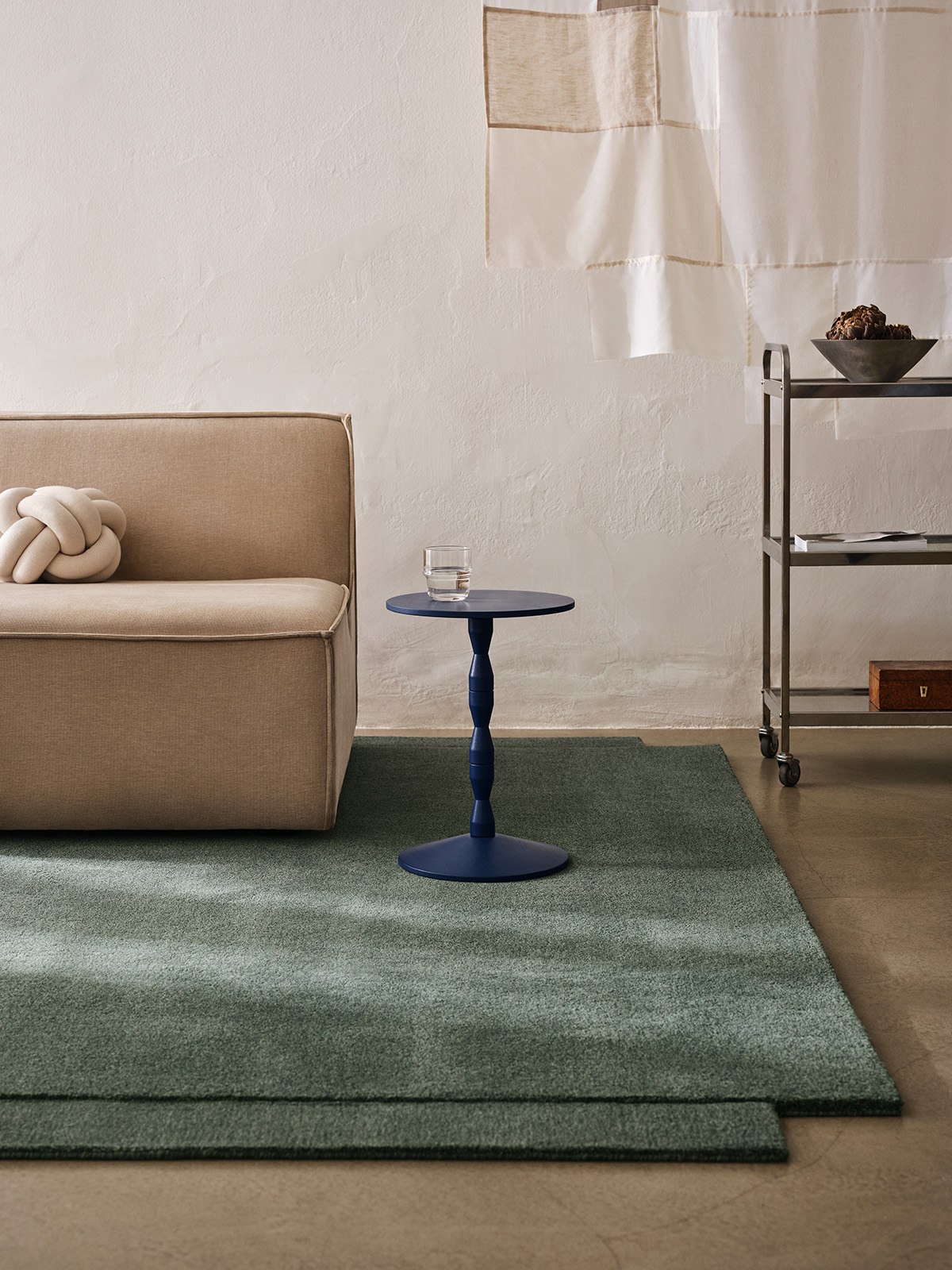 Level Rug in green colorway anchoring a minimalist living space with furniture arranged to highlight its dimensional qualities.